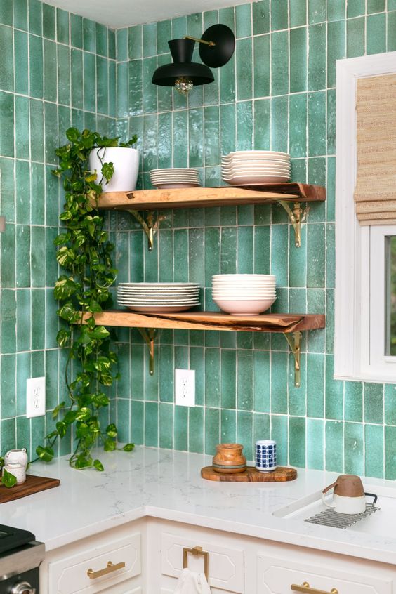 a modern white kitchen spruced  up with a bold green skinny tile backsplash, open shelves and some gold touches