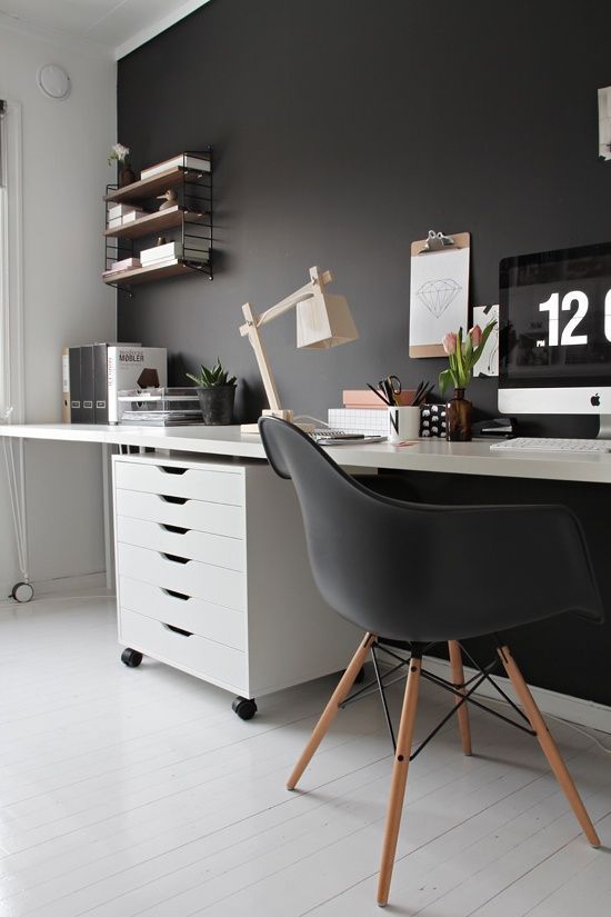 a moody Scandi home office with a black statement wall, chair and soem decor and white as the base