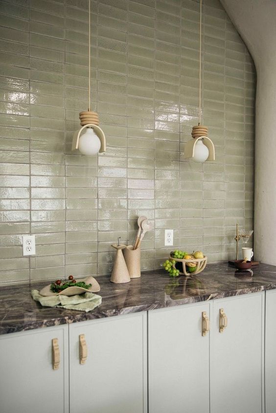 a peaceful mint kitchen with a stone countertops, an olive green skinny tile backsplash and pendant lamps