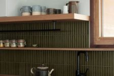 a refined modern kitchen with stained cabinets, green skinny tiles, open shelves, black fixtures is a chic and cool idea