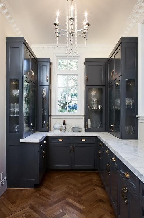 a small black vintage kitchen with white stone countertops looks rather formal, refined and very elegant