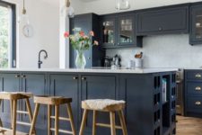 a stylish black farmhouse kitchen with white countertops and touches of wood to soften the look