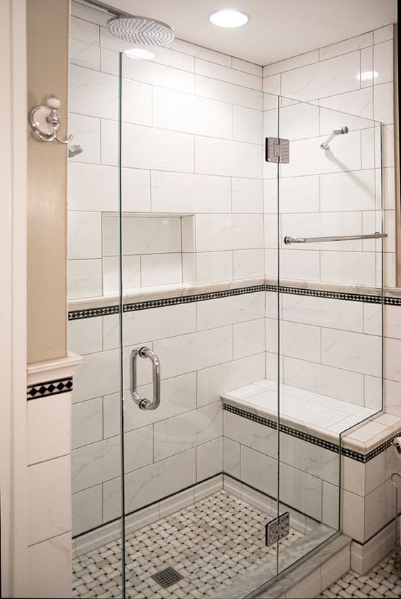 A stylish monochromatic shower space done with a built in bench and a mosaic floor