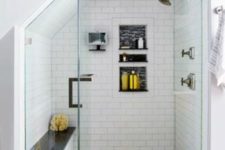 a stylish monochromatic shower with a built-in bench with a black seat that matches the floor and adds drama