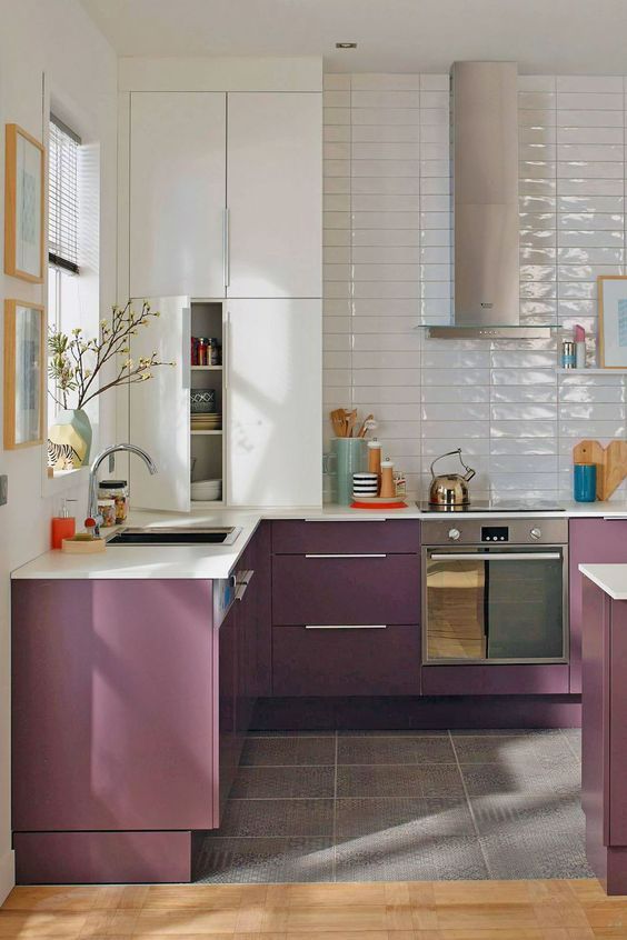 A two tone kitchen with white and purple cabinets, a white tile backsplash and white countertops is a bold and catchy space