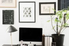 an elegant Scandinavian home office with a blakc trestle desk, a leather chair and a black and white gallery wall