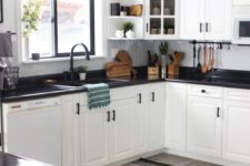 stylish white kitchen cabinets accented with dark stained countertops and black hardware for a bold look