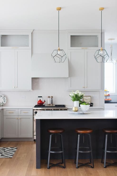 the black kitchen island features a white countertop, the same as on the cabinets to tie them up