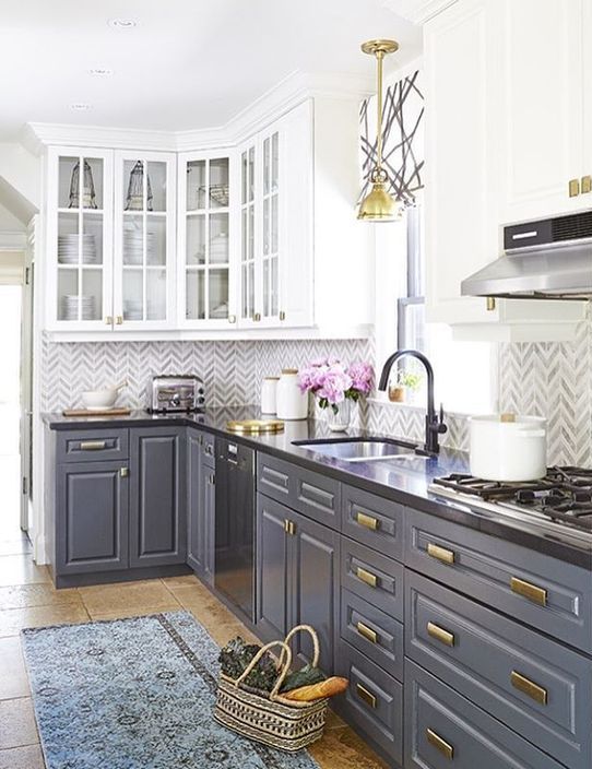 this grey and white kitchen with dark countertops features two trends in one - two colors and contrasting countertops