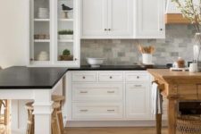 vintage-inspired white cabinets with black countertops and a grey marble tile backsplash for a cozy farmhouse kitchen