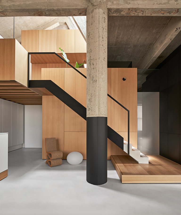 There's a minimalist staircase and a wooden platform plus some catchy furniture