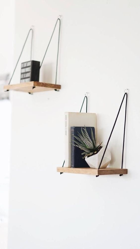 simple and chic shelves with contrastign black threads and little rings on the walls for a modern or boho chic space