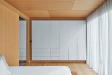 04 The master bedroom is super minimal and sleek – there’s a bed and a large storage unit plus lots of light colored wood