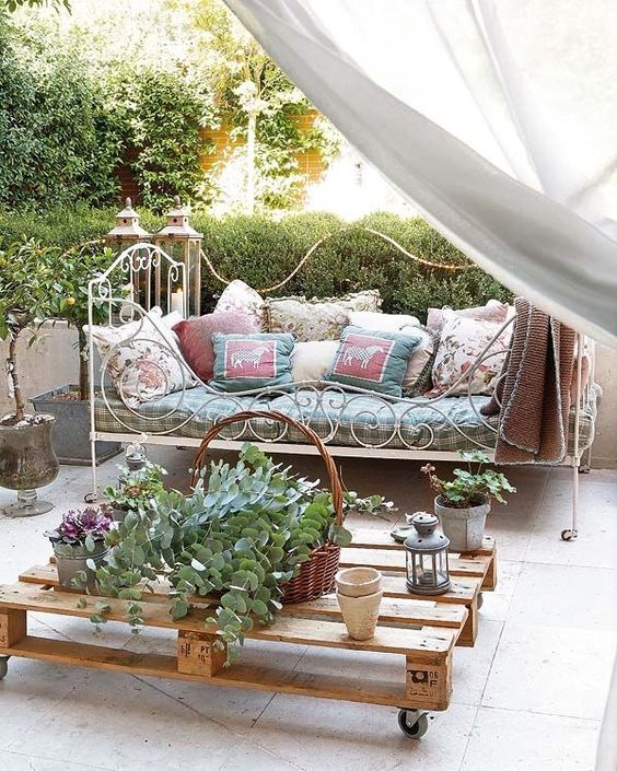 a super elegant and French chic forged daybed with lots of pillows on casters is a great piece for a romantic area