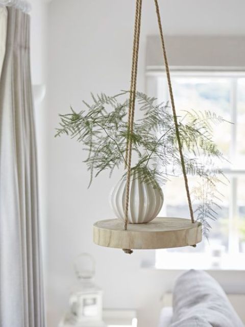 a cool and easy hanging shelf of a thick wood slice and ropes can be easily DIYed and will add a dreamy feel to the space