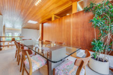 06 The dining room is done with colorful chairs and a glass dining table and there’s a glazed wall for views and light