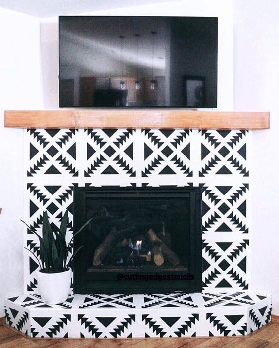 Super bright black and white geometric tiles and a light stained wood mantel for a boho chic living room