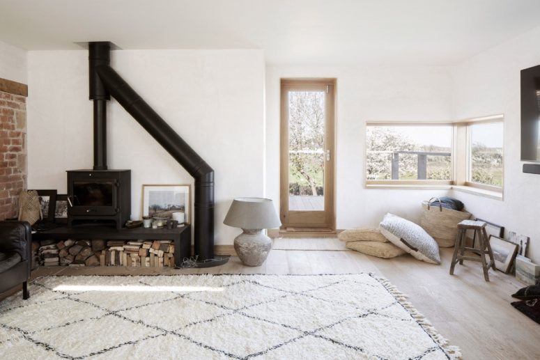 The living room is a welcoming space, with a hearth, pillows, views and much natural light