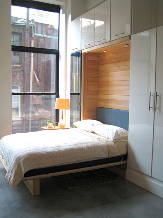 a stylish Murphy bed with wood clad inside and sleek storage units on all the sides