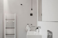 10 The bathroom is minimalist, with white marble tiles and bulbs plus a wall-mounted sink