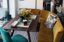 10 a curved mustard bench and a teal chair are paired to create a cozy mid-century modern breakfast nook