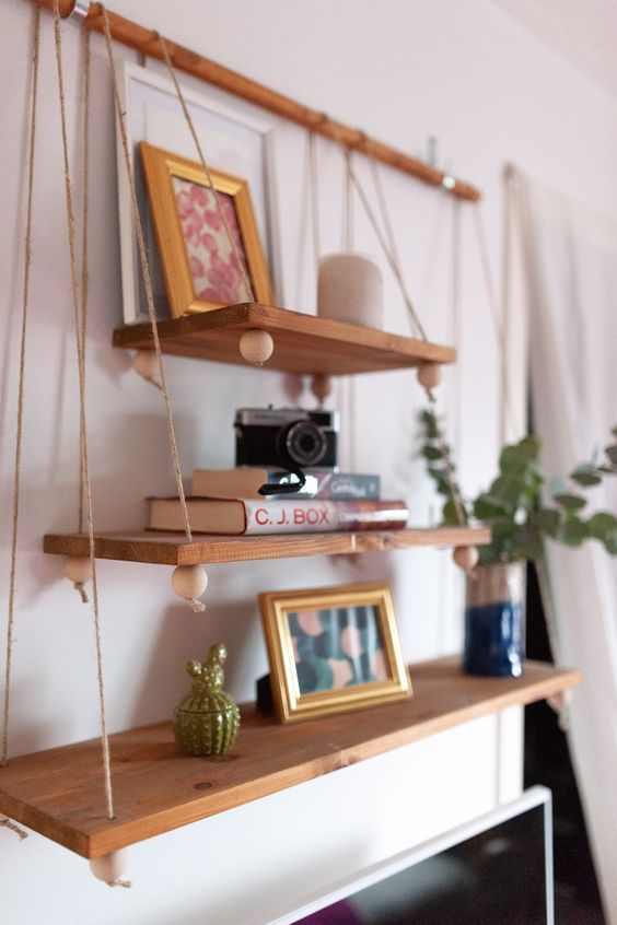 a boho hanging shelf composed of several tiers of various sizes, beads on a wooden holder