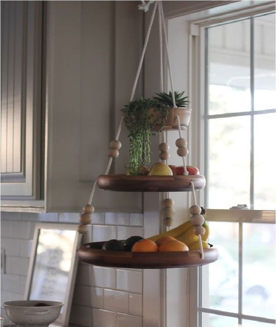 a fun hanging shelf for fruit with beads and ropes and some succulents on top is a cute and easy idea