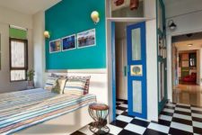 14 a retro bedroom with a black and white tile floor, a teal wall and a bright blue door for more color