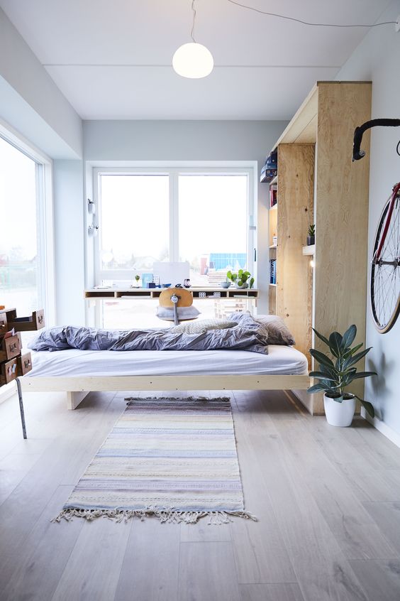 A Nordic light filled bedroom with a Murphy bed integrated into a storage unit