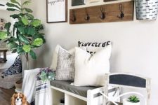 16 a bright summer entryway with potted greenery, a gallery wall in black and white and a chalkboard chair