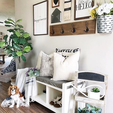 a bright summer entryway with potted greenery, a gallery wall in black and white and a chalkboard chair