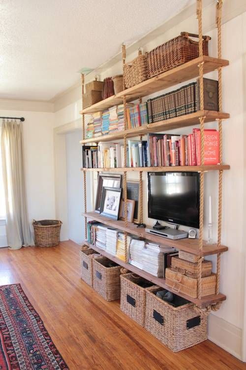 a large hanging shelving unit with thick rustic wooden shelves and thick ropes plus baskets under it for more organization