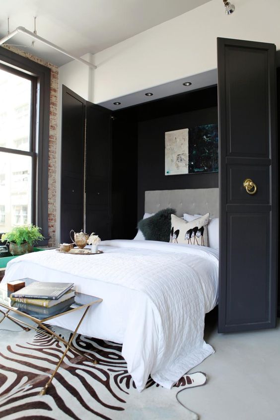 a stylishly hidden Murphy bed with black doors and ring pulls is a gorgeous idea for a refined bedroom
