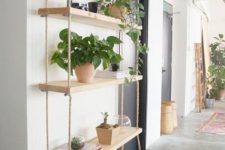 17 a large shelving unit with several tiers and thick ropes is a fresh take on a traditional console table that doesn’t take floor space