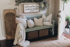 18 a cozy farmhouse summer entryway with a light blue bench, greenery and a greenery wreathh plus wood