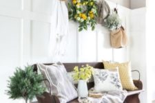 19 a potted plant in a bucket, a greenery and citrus wreath, yellow blooms and botanical print pillows for summer vibes