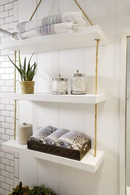 a simple and smart bathroom hanging shelf with thick white shelves and ropes can be easily DIYed