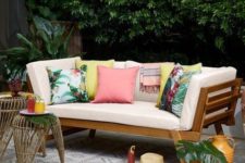 19 a simple modern wooden daybed with colorful pillows that give it a tropical feel and make it brighter