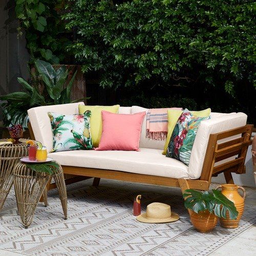 a simple modern wooden daybed with colorful pillows that give it a tropical feel and make it brighter