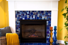 20 a fireplace clad with bright mosaic blue tiles continues the yellow and blue color scheme of the space