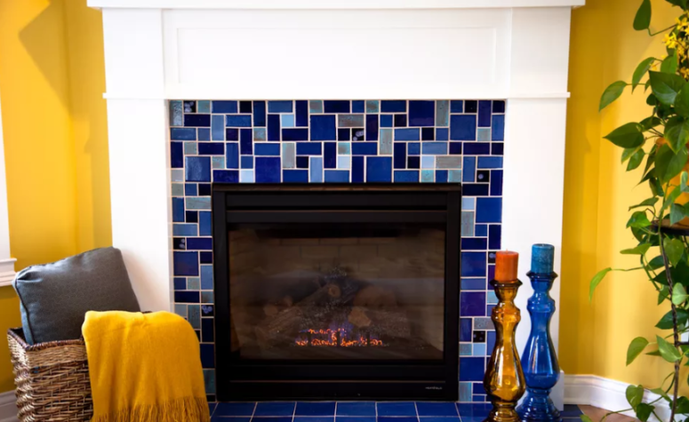 a fireplace clad with bright mosaic blue tiles continues the yellow and blue color scheme of the space