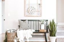 21 a summer farmhouse entryway with a succulent in a pot, a basket with greenery, a candle lantern, a bench and a pompom blanket