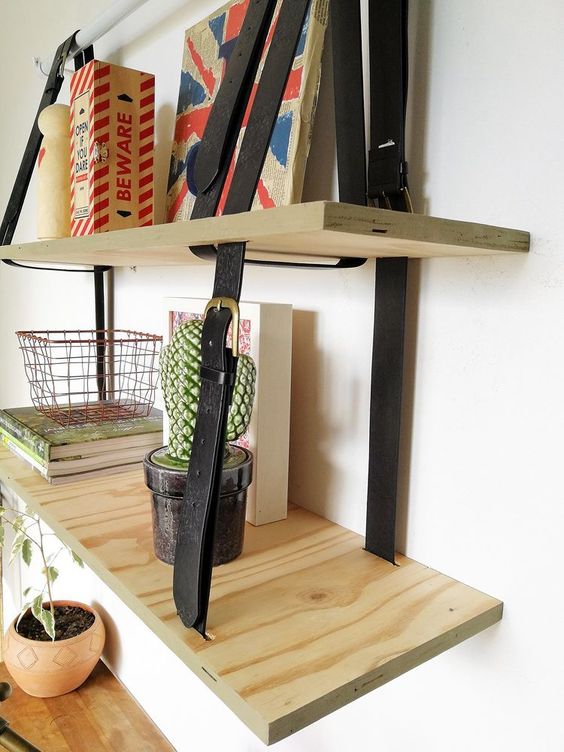 A two layered hanging shelving unit done with plywood and leather belts is a cool modern idea