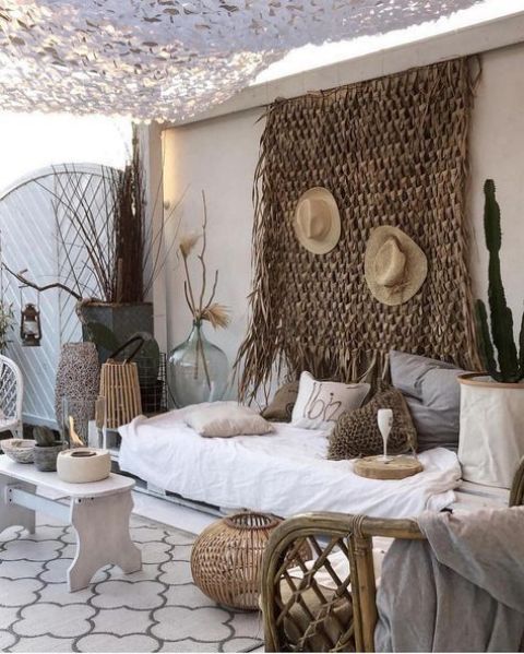 A whitewashed pallet daybed with lots of crochet pillows is the centerpiece of this desert inspired boho outdoor space