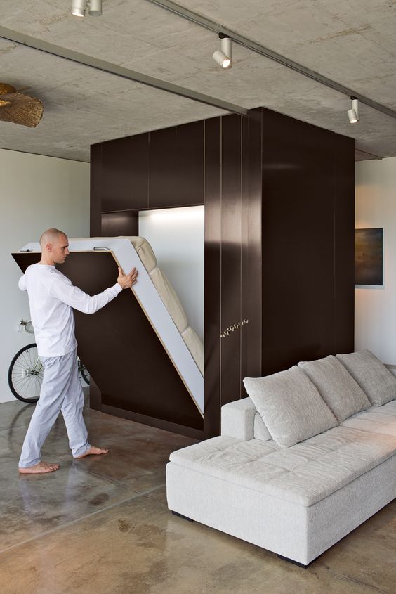 an industrial loft with a metal cube, which hides a Murphy bed, means no compromise on style and decor