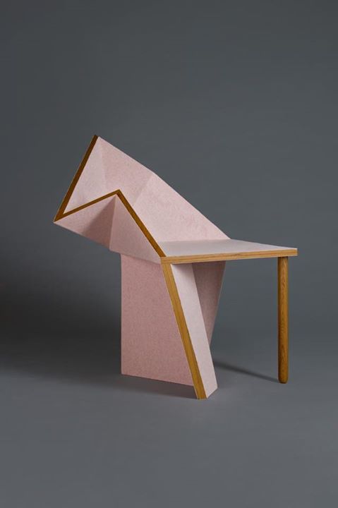 a unique pink geometric chair with a single leg and a solid base, which is shaped sculpturally