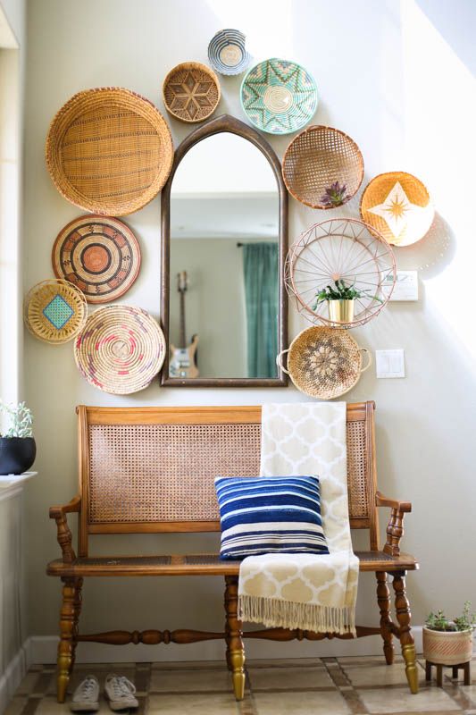 give your entryway a bold summer feel with a wall of decorative baskets - painted and printed ones and a striped pillow