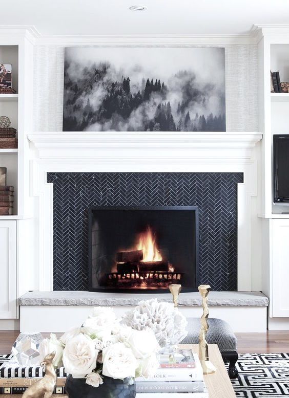 if you have a monochromatic space, clad your fireplace with black tiles in a herringbone pattern and add stone for a chic look