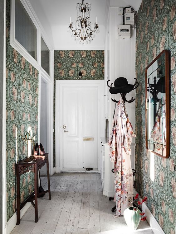 moody green floral wallpaper covering all the walls takes over the whole space and makes it cooler