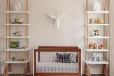 25 shelving units hanging on ropes with tassels on both sides of the crib is a cool idea that brings a relaxed feel to the space